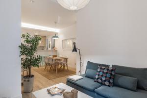 ein Wohnzimmer mit einer blauen Couch und einem Tisch in der Unterkunft Waou Chamberi V - Alquiler Corta Duración in Madrid