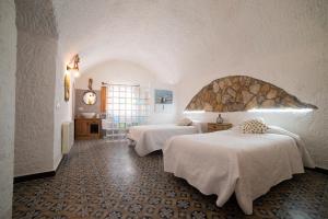 pokój hotelowy z dwoma łóżkami w pokoju w obiekcie Cuevas Cortijo Gachas w mieście Guadix