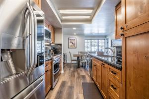 a kitchen with wooden cabinets and stainless steel appliances at Ski in Ski Out 3 Bedrm 3 Bathrm fully remodeled Sierra Megeve Condo Steps to Canyon Lodge Sleeps 8 in Mammoth Lakes