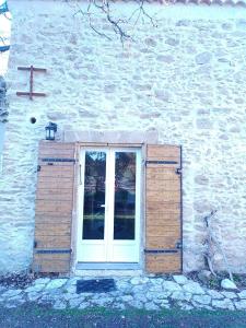 a window with a cross on the side of a building at Sous un chêne bicentenaire agréable Chambre avec jardin et espace de W in Lambesc