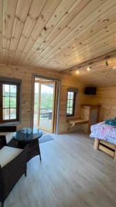 Zimmer mit einem Bett und einem Tisch in einer Hütte in der Unterkunft Beautiful Wooden tiny house, Glamping cabin with hot tub 2 in Tuxford