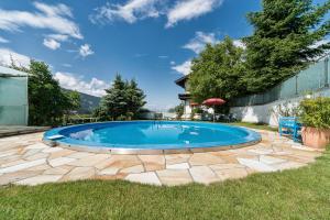 a large swimming pool in a yard with a stone patio at Ferienwohnungen Sumperer in Pill