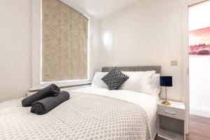 ein Schlafzimmer mit einem Bett mit zwei Kissen darauf in der Unterkunft Townhouse for Professionals (5 Bedroom 5 Ensuite) in Ipswich