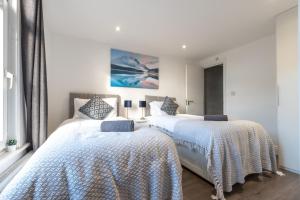 zwei Betten in einem Schlafzimmer mit weißen Wänden in der Unterkunft Townhouse for Professionals (5 Bedroom 5 Ensuite) in Ipswich + 24 Fotos