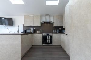 eine Küche mit Küchengeräten aus Edelstahl und braunen Schränken in der Unterkunft Townhouse for Professionals (5 Bedroom 5 Ensuite) in Ipswich