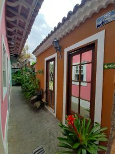 a house with a door and a courtyard with plants at Pousada Villa de Cananea in Cananéia