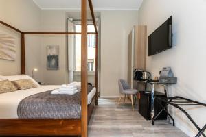 a hotel room with a bed and a flat screen tv at Suites 44 - Guesthouse close to Vaticano, San Pietro, Castel Sant'angelo in Rome +102 photos