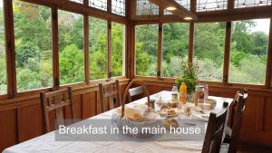 Bluff Hill Bed & Breakfast في نابيير: غرفة طعام مع طاولة في غرفة مع نوافذ