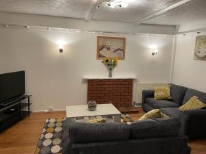 a living room with two couches and a fireplace at Wilford House in Great Billing