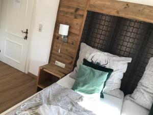 Schlafzimmer mit einem Bett mit einem Kopfteil aus Holz und Kissen in der Unterkunft Landhaus Aigner in Allhartsberg