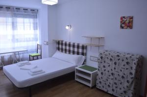 a small room with a bed and a table at ArArAt Hostel in Santiago de Compostela