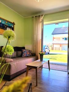 a living room with a couch and a table at Apartament Laurowy in Darłowo