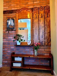 a brick wall with a dresser and a mirror at Apartament Laurowy in Darłowo