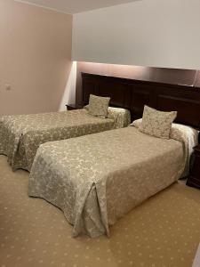 two beds sitting next to each other in a hotel room at Alpin Apart Hotel Poiana Brasov2409 in Braşov +24 photos