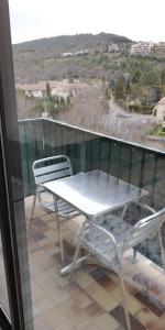 een witte tafel en 2 stoelen op een balkon bij Studio Lou Cigaloun in Gréoux-les-Bains