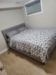 a bedroom with a bed with a black and white comforter at House of Love in Winnipeg