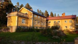 un grand bâtiment avec un toit rouge dans une cour dans l'établissement Äppelbo Gästgiveri, à Äppelbo