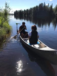 a man and a woman sitting in a canoe on a lake at Äppelbo Gästgiveri in Äppelbo