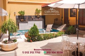a pool with chairs and an umbrella and a table at Hotel Casa Danna in Colima