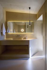 ein Bad mit einem Waschbecken und einem Spiegel in der Unterkunft Santopaz Suites in Oia