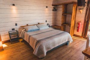1 dormitorio con 1 cama en una habitación con paredes de madera en Morros del Pacífico en Pichilemu