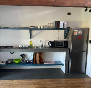 una pequeña cocina con fregadero y nevera. en Morros del Pacífico, en Pichilemu