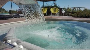 a water fountain in a swimming pool with two chairs at Oroverde in Bergeggi