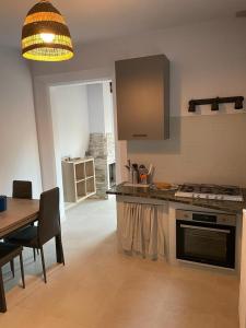 a kitchen with a table and a stove top oven at Azzurra House in Marina di Pisa