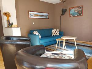 sala de estar con sofá azul y sillas en Le Bullière 60m2 plein centre! en Rodez