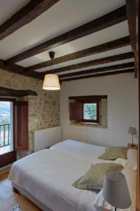 a bedroom with a large white bed in a building at Casa de Aldea Casa de Rubio in Linares