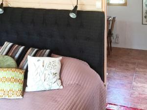 1 cama con cabecero negro y espejo en Holiday home STJÄRNHOV, en Stjärnhov