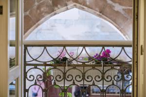 ein Fenster mit lila Blumen auf dem Balkon in der Unterkunft Hostal Suso in Santiago de Compostela