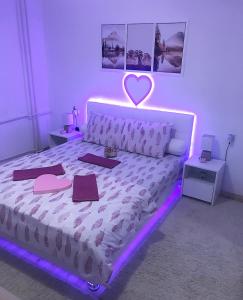 a bedroom with a bed with a heart light on it at Apartman Dunja in Prijedor