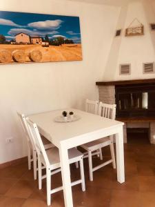 a white table and chairs in a room with a fireplace at 1727 B&B La via degli Dei in Monzuno