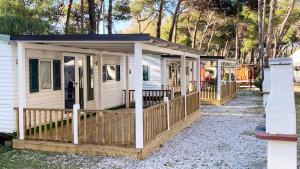 a tiny house with a porch and a deck at Camping Village Mare Pineta in Paestum