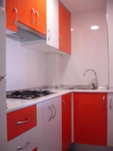 una cocina con armarios rojos y blancos y fregadero en Primavera - Zand Properties, en Benidorm