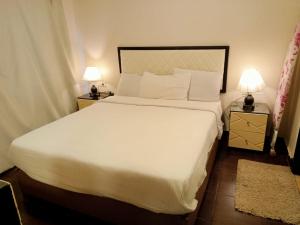 a bedroom with a large white bed with two lamps at Apartment in Porto Sharm VIP in Sharm El Sheikh