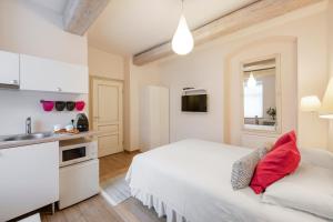 Dormitorio blanco con cama blanca y lavamanos en Guoda Apartments, en Vilna