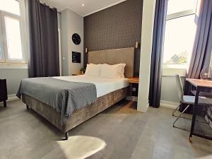 a bedroom with a bed and a desk and windows at Casa do Salgueiral Douro in Peso da Régua +108 photos