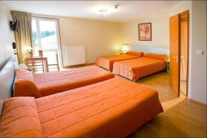 a hotel room with two beds and a window at Hôtel La Métairie 2 étoiles in Cordes-sur-Ciel