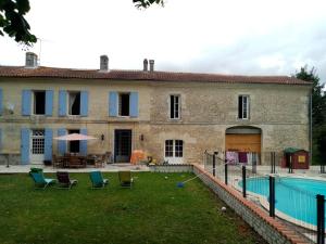 una vecchia casa con una piscina di fronte di les Ormes de Belluire a Belluire