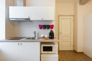Una pequeña cocina con fregadero y microondas. en Guoda Apartments, en Vilna 2 fotos más