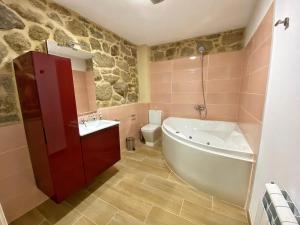 ein Badezimmer mit einer Badewanne, einem Waschbecken und einem WC in der Unterkunft Casa do Veiga in Chantada