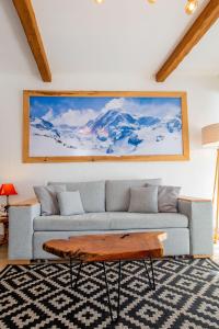 een woonkamer met een bank en een tafel bij Aux pieds des pistes, Les 2 Alpes in Vénosc