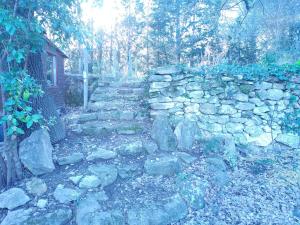a stone wall with a bunch of rocks at Sous un chêne bicentenaire agréable Chambre avec jardin et espace de W in Lambesc