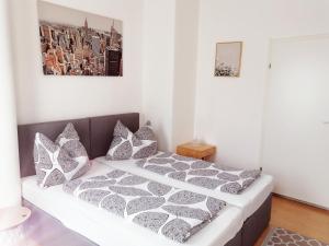 sypialnia z łóżkiem z szarymi i białymi poduszkami w obiekcie Betterhome Apartments am Stadion I Free Parking I Self Check-in w Grazu