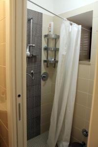 a shower with a white shower curtain in a bathroom at Kame house in Castelbuono