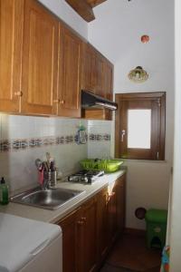 una cocina con armarios de madera y fregadero en Kame house, en Castelbuono