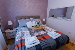 ein Schlafzimmer mit einem Bett mit Handtüchern darauf in der Unterkunft Apartman Kristina 4* in Subotica