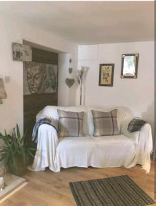 a living room with a white couch with pillows at LAVENDER COTTAGE in Whitby